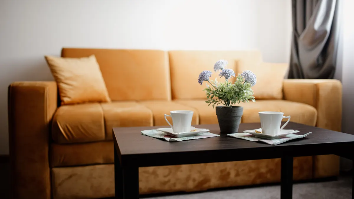 Deux tasses de café sur une table basse, devant un canapé