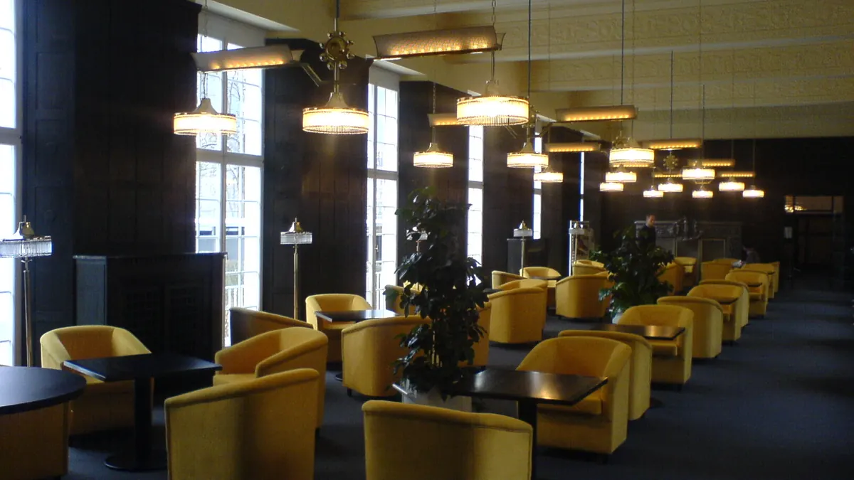 Salon aux fauteuils jaunes inoccupés, sous un éclairage tamisé