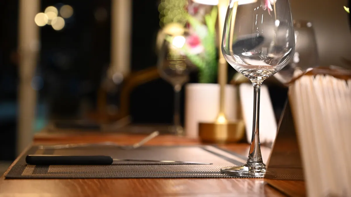 Verre à vin sur une table de bar, lumières tamisées en arrière-plan
