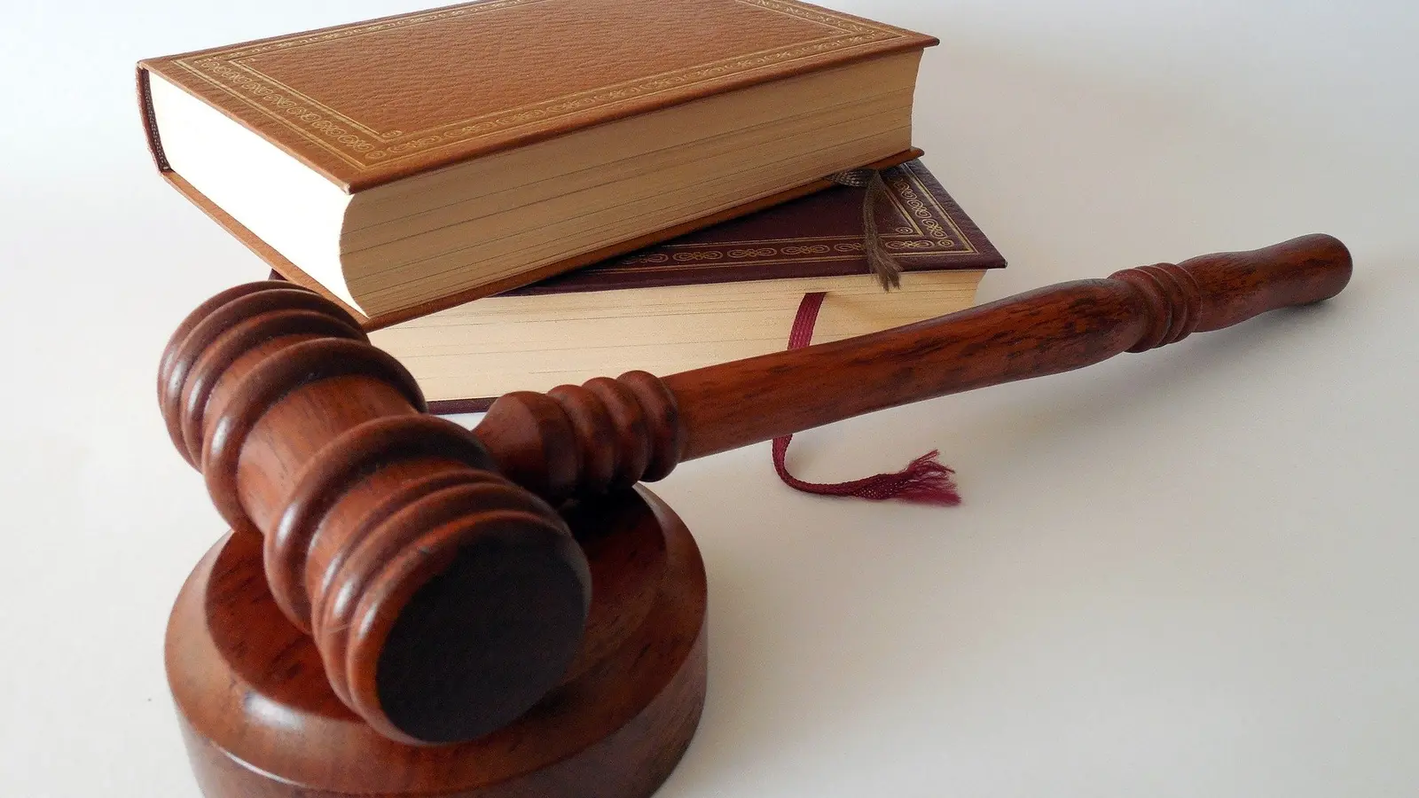 Marteau de juge en bois devant deux livres reliés