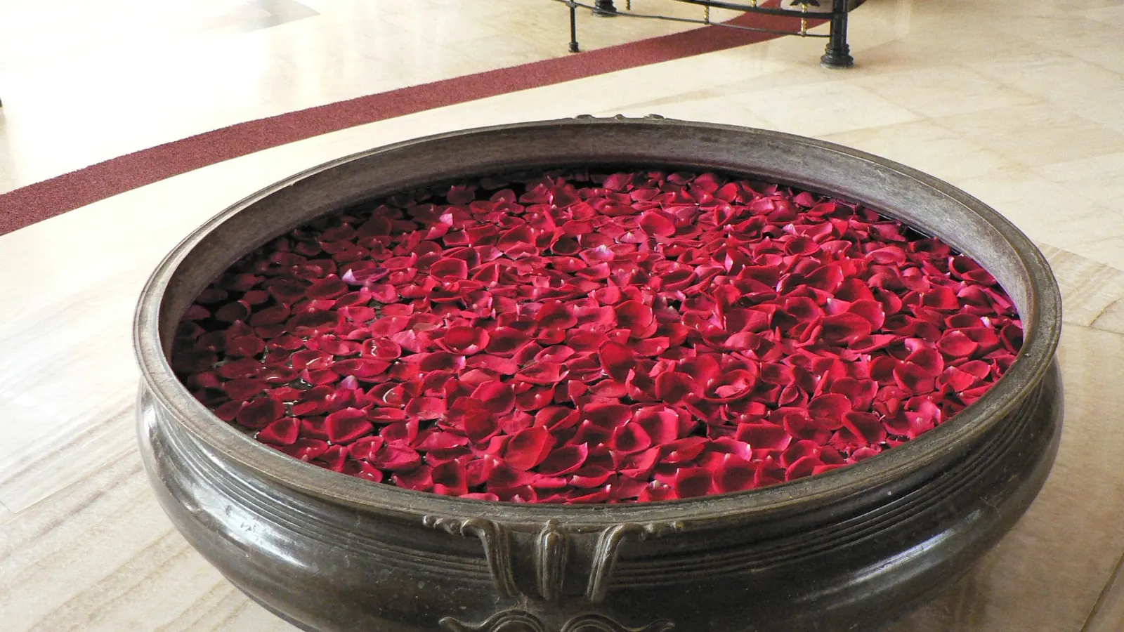Coupe en métal remplie de pétales de roses rouges